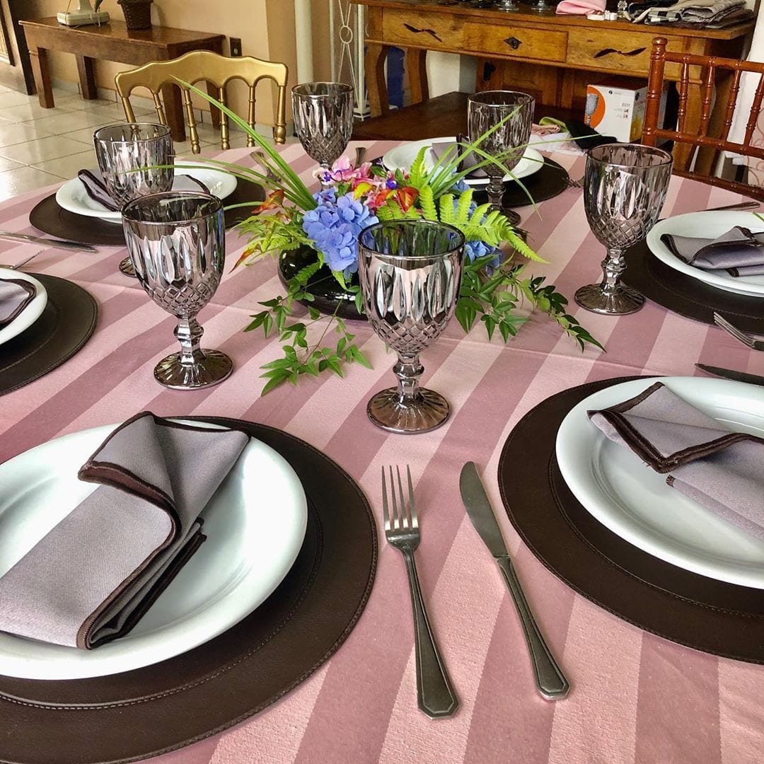 Mesa posta em tons de rosa com taças de cristal